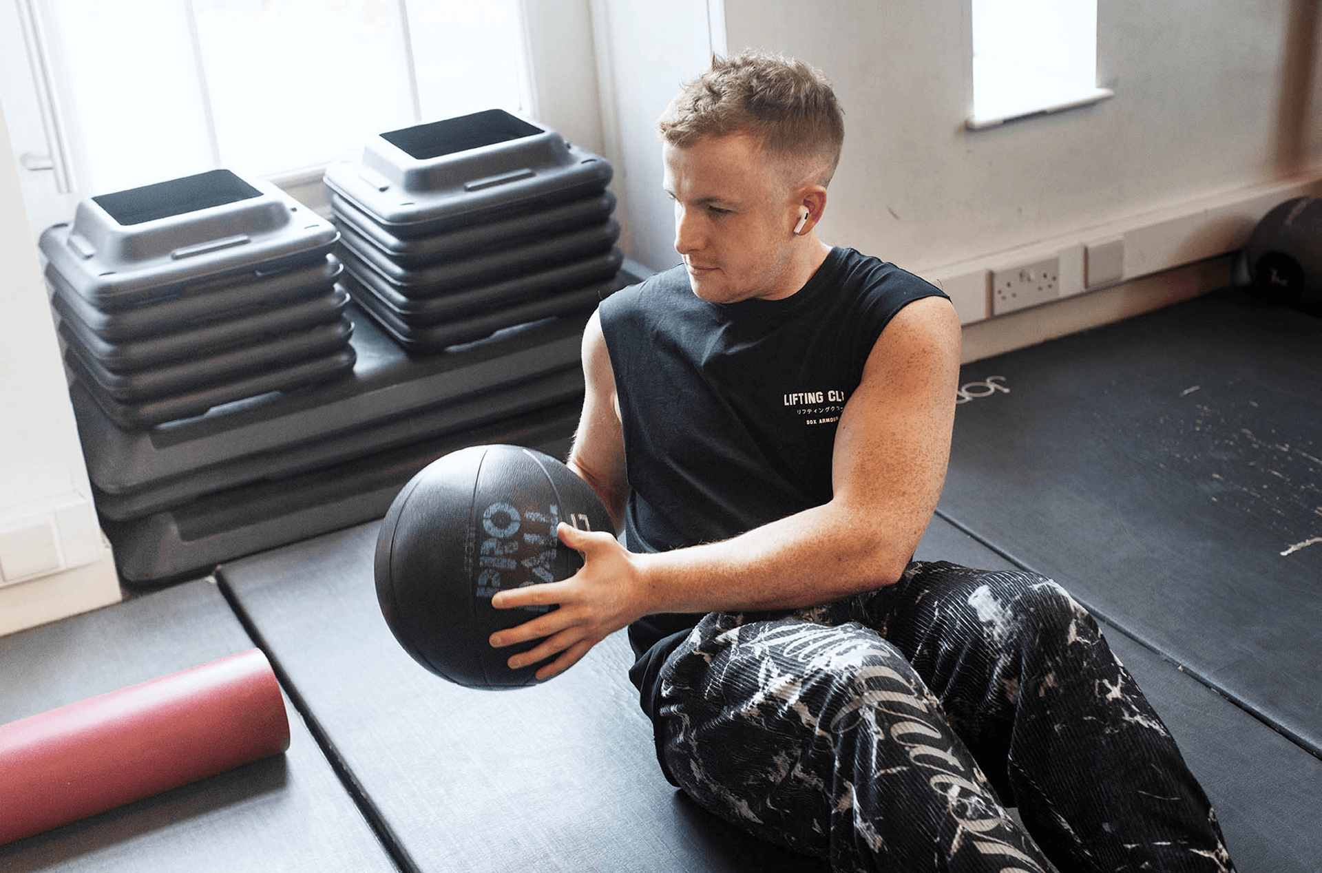 Mann trainiert im Fitnessstudio mit Medizinball