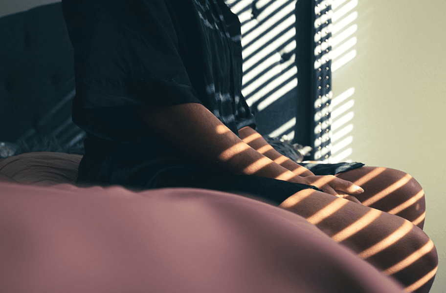 Frau sitzt auf einem Bett