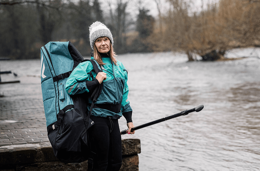 Frau mit Sporttasche am Fluss